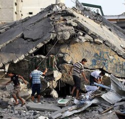 Men inspect the rubble of a destroyed building in Gaza in summer 2014. © Getty