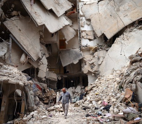 A man walks amid a destroyed building in Aleppo, Syria. © DIMITAR DILKOFF/AFP/Getty Images